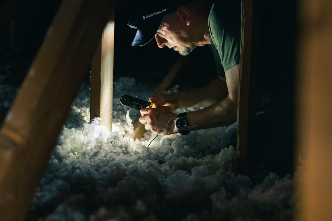 Inspector working in an attic with a flashlight