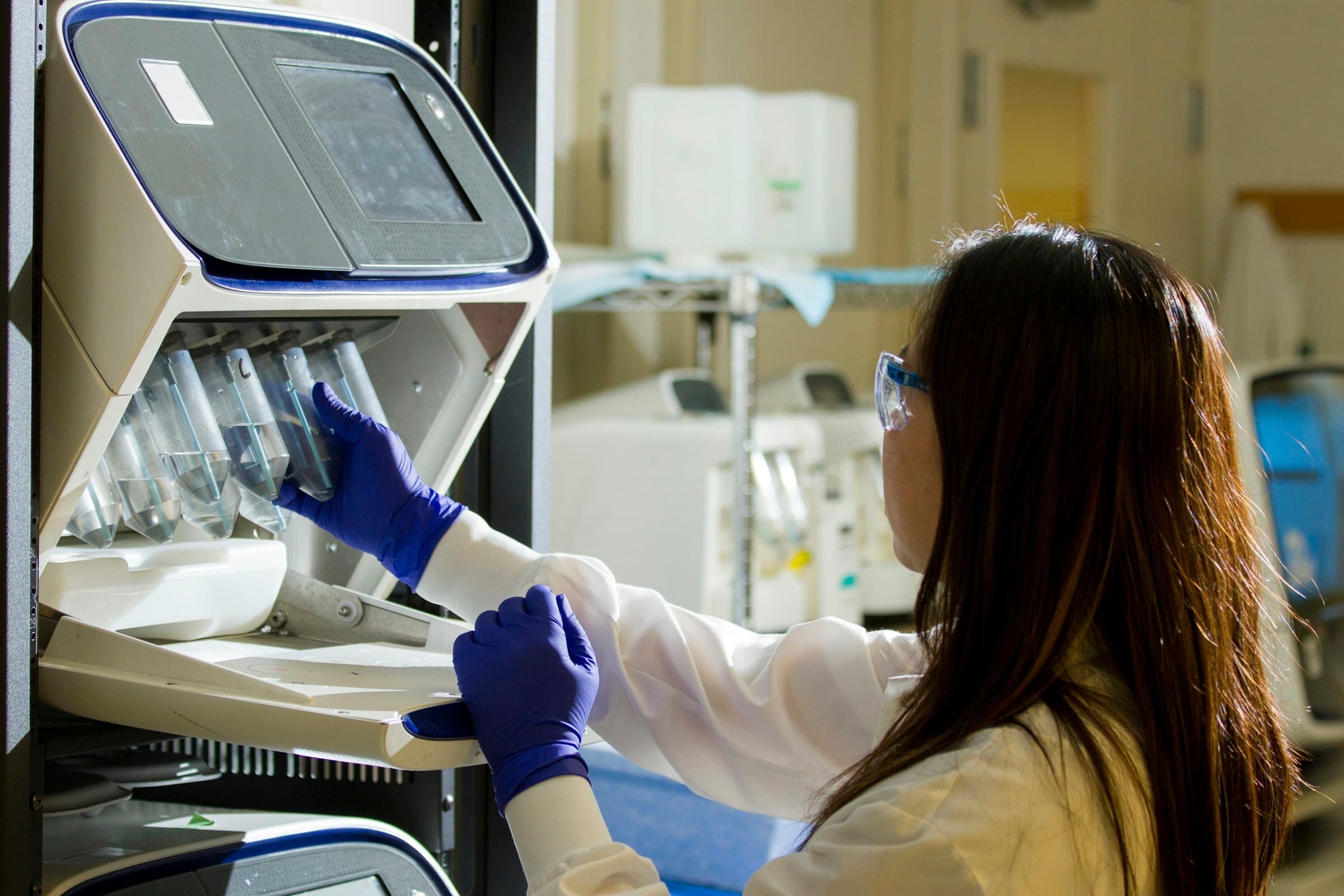 Lab technician in gloves loading samples for asbestos analysis