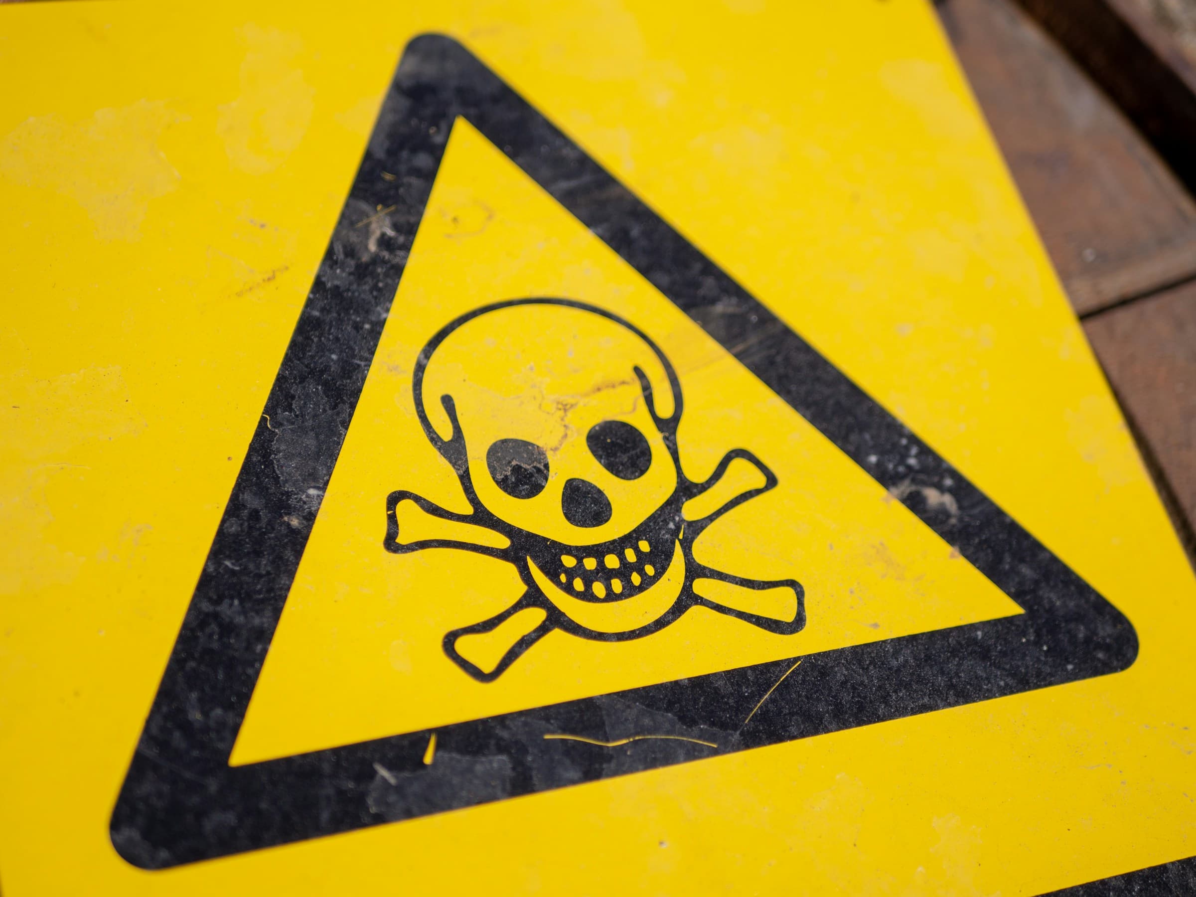 Yellow triangle hazard sign with skull-and-crossbones symbol