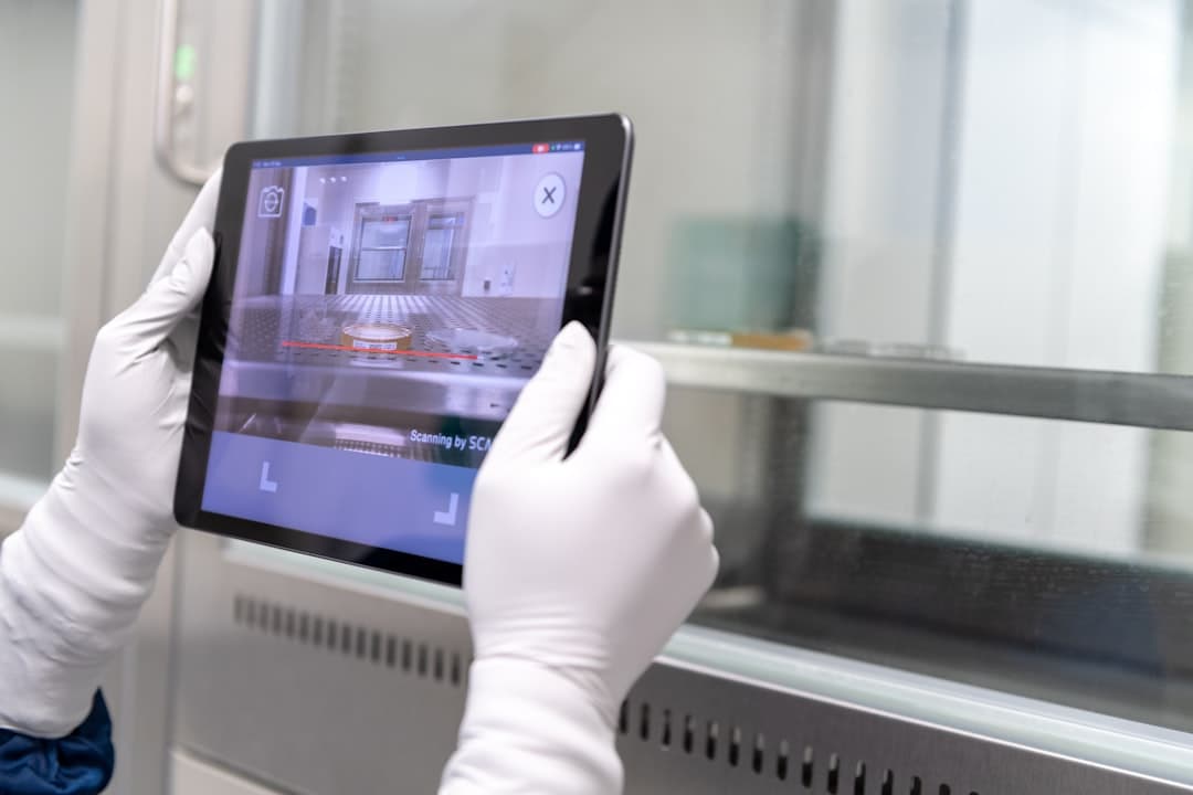 Scientist reviewing analysis on a tablet at the lab bench
