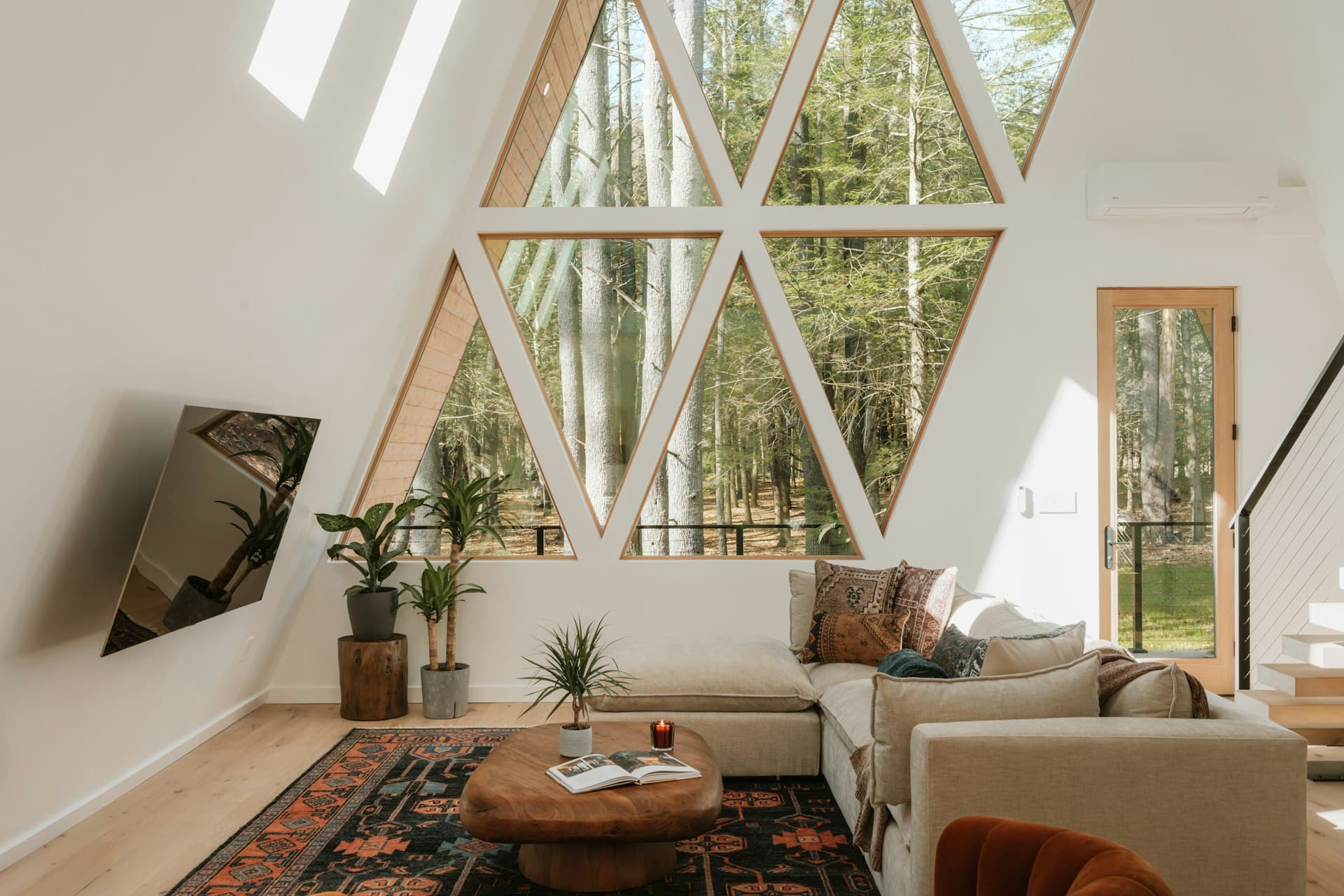 Bright modern living room with large windows opening to forest